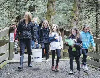  ?? MIKE RUSSELL ?? Crofton Elementary School teacher Angella Campbell and her students prepare to release salmon they raised from eggs into Stocking Creek.