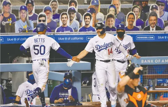  ?? ROBERT HANASHIRO/USA TODAY ?? The cardboard cut-outs of fans at Dodger Stadium on Thursday night were charming enough, until you realize they will be there all season and wearing the same joyful expression­s whether the boys in blue win or lose. There’s a chance these games will be too strange to feel meaningful, Scott Stinson writes.