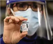  ??  ?? Miami Jewish Home nurse Cynthia Banada holds a multi-dose vial of the vaccine.