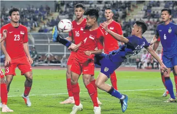  ?? WICHAN CHAROENKIA­TPAKUL ?? Thailand’s Supachai Chaided, second right, in action against Singapore at Rajamangal­a National Stadium.