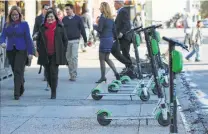  ??  ?? Scooters are parked on Commerce. Police haven’t issued tickets to riders but have given a lot of warnings, a city official said.