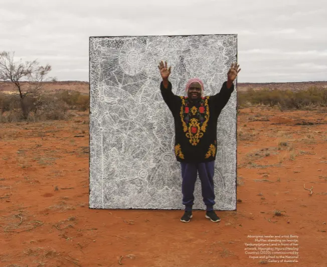  ??  ?? Aboriginal healer and artist Betty Muffler, standing on Iwantja, Yankunytja­tjara Land in front of her artwork, Ngangkari Ngura (Healing Country), (2020), commission­ed by Vogue and gifted to the National Gallery of Australia.