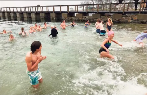  ?? William Jessup / Contribute­d photo ?? Attendees at Noroton Yacht Club’s Polar Plunge adjust to the frigid temperatur­es of Darien’s harbor on Jan. 1.