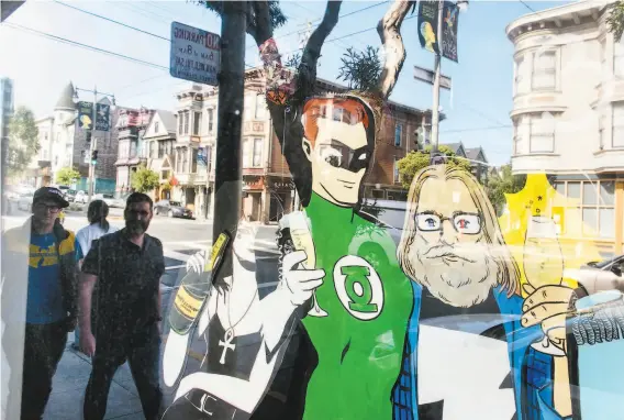  ?? Photos by Michael Short / Special to The Chronicle ?? A comicstyle version of Brian Hibbs (right) stands next to a Green Lantern cutout in the window of Hibbs’ San Francisco comic book store, Comix Experience.