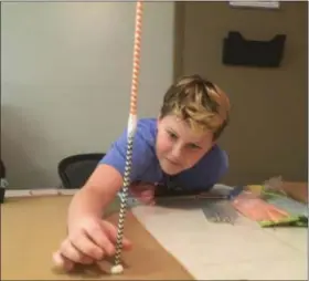  ?? ZACHARY SRNIS — THE MORNING JOURNAL ?? Gavin Davis, 11, an Elyria sixth-grader, builds the foundation of his structure with straws.