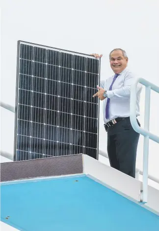  ?? Picture: JERAD WILLIAMS ?? Mayor Tom Tate with one of the 1300 solar panels to be installed at the Gold Coast Aquatic Centre, Southport, saving $100,000 a year in electricit­y costs.