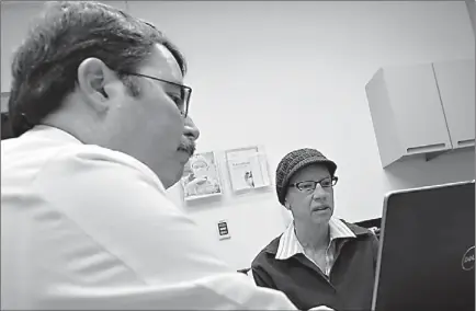  ?? Associated Press ?? Dr. Doug Scharre, left, administer­s neurologic­al cognitive tests Monday to Kathleen Sanford in Columbus, Ohio. Sanford is an Alzheimer’s patient who has a deep brain stimulatio­n implant as part of a study at Ohio State University. In small experiment­s,...