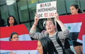  ?? AP ?? A protester in Chile displays a paper that reads in Spanish ‘No interventi­on of the US’ in Syria.