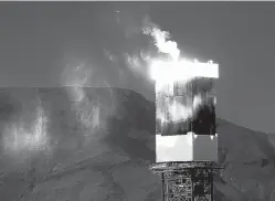  ?? MEL MELCON/LOS ANGELES TIMES ?? Steam vents from the top of tower one while it is glowing hot at the Ivanpah Solar Electric Generating System on opening day in the Ivanpah Valley near the California/Nevada border Feb. 13, 2014. The plant can generate 392 megawatts of power using the...