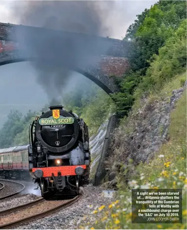  ?? JOHN COOPER-SMITH ?? A sight we’ve been starved of… Britannia shatters the tranquilli­ty of the Cumbrian fells at Waitby with a southbound charge over the ‘S&C’ on July 10 2019.