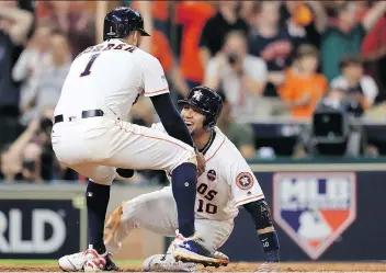  ?? RONALD MARTINEZ/GETTY IMAGES ?? Houston Astros Carlos Correa and Yuli Gurriel celebrate after they scored on an Alex Bregman double against New York Yankees reliever David Robertson in the eighth inning Friday as the Astros forced Game 7 in the ALCS with a 7-1 win at Minute Maid Park...