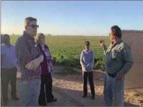  ??  ?? Dr. Mark Lagrimini, vice provost of Research and Extension (in foreground to the left in plaid shirt) and Dr. Wendy Powers, associate vice president of the University of California Division of Agricultur­e and Natural Resources (in red jacket), listen to Holtville farmer Ronnie Leimgruber during a recent tour of Imperial Valley. COURTESY PHOTO