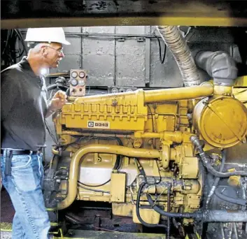  ?? Darrell Sapp/Post-Gazette photos ?? Gary Sedlacek, a consulting engineer with Life Cycle Engineerin­g, looks at a 500-horsepower diesel engine aboard the Principio towboat on Thursday. Mr. Sedlacek said natural gas will power the engine by up to 60 percent and help the diesel burn cleaner.