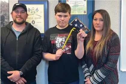  ?? Photograph: Steve Schulwitz/The Alpena News, via AP ?? Andrew Burns, left; Owen Burns, center; and Margaret Burns pose with a slingshot Owen used to thwart an alleged kidnapping attempt on his sister a week earlier.