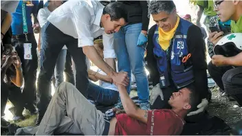  ?? PHOTO AFP ?? Le président autoprocla­mé Juan Guaido salue un bénévole d’un mouvement Aid and Freedom Venezuela Coalition qui s’est évanoui lors d’un rallye samedi à Caracas.