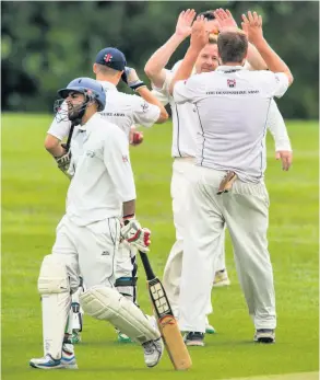  ??  ?? Celebratio­ns for Bear Flat as a Nationwide House batsman is sent back to the hutch