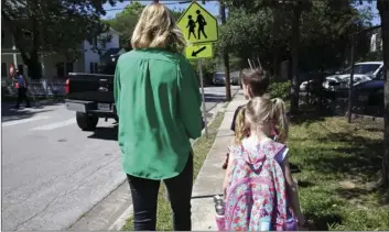  ?? AP PHOTO/JOHN L. MONE ?? In this May 4 photo Joanna Smith, of Houston, walks her twin first-graders home from school. One of her children is transgende­r and Smith fears the child’s school would be compelled by the state to “out” her child’s biological gender should a “bathroom...