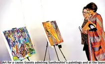  ?? ?? Art for a cause: Guests admiring Santhoshin­i’s paintings and at the launch. Pix by Akila Jayawarden­a