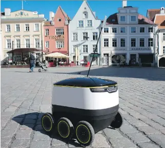  ?? PHOTOS: PETI KOLLANYI/BLOOMBERG ?? A prototype self-driving parcel delivery robot, developed by Starship Technologi­es, travels across a cobbleston­e square during testing in the city centre in Tallinn, Estonia. Top right, an engineer loads parcels before the test run.