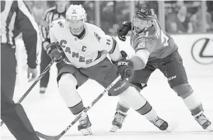  ?? JIM RASSOL/AP ?? Carolina Hurricanes center Jordan Staal battles for possession of the puck against Panthers center Vincent Trocheck during the second period of Tuesday’s game. The Panthers surrendere­d four first-period goals and fell to a 6-3 defeat.