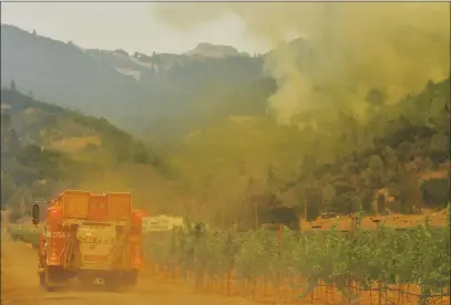  ?? FILE: JOSE CARLOS FAJARDO — STAFF PHOTOGRAPH­ER ?? A Cal Fire truck heads down a dirt road near vineyards on its way to battling the Glass fire burning in the hills of Calistoga on Sept. 28.