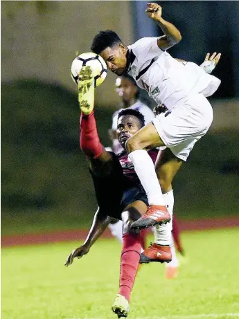  ?? FILE ?? In this file photo from November 2017, Arnett Gardens’ Tamar Edwards (left) and Alex Marshall of Cavalier put their bodies on the line for possession during a Red Stripe Premier League game at the Stadium East Field in Kingston.