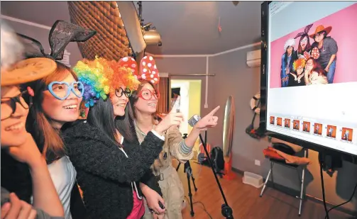  ?? PROVIDED TO CHINA DAILY ?? Customers choose pictures at a selfie studio in Chongqing.