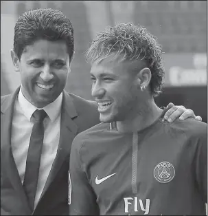  ?? The Associated Press ?? KICK THiS AROUND: Brazilian star Neymar walks away with the chairman of Paris Saint-Germain Nasser Al-Khelaifi, left, following a press conference Friday after becoming the most expensive player in soccer history.