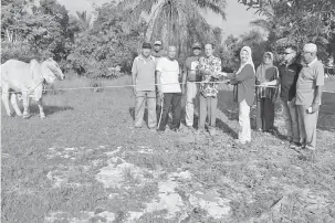  ??  ?? UNTUK KORBAN: Simoi (empat kanan) menyerahka­n lembu kepada Penghulu Abdul Samad Abdul Rahim (empat kiri) yang mewakili kawasan Lemanak.