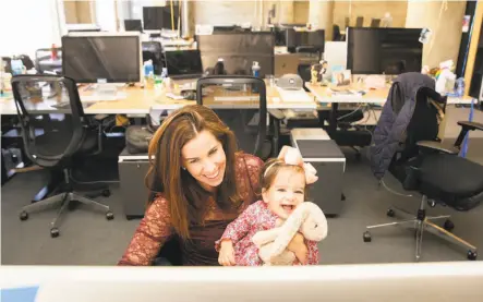  ?? Photos by Brittany Hosea-Small / Special to The Chronicle ?? Morgan Mohun-Gholson at her desk with her 1-year-old daughter, Chloe Gholson, at Pinterest’s San Francisco headquarte­rs.