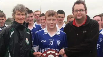  ??  ?? Winning captain Tommy Kennedy with Marguerite Furlong of Coiste na nOg and Dean Goodison.