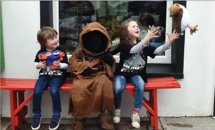  ?? Photo Don MacMonagle. ?? Brother and sister Rory and Laura Conway with a friendly Jawa as Laura tires to catch a flying Porg at the May The Fourth Be With You festival in Portmagee.