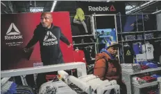  ?? AP PHOTO/EDUARDO MUNOZ ALVAREZ ?? A man walks past a Reebok display at the Walmart Supercente­r in North Bergen, N.J., on Feb. 9.