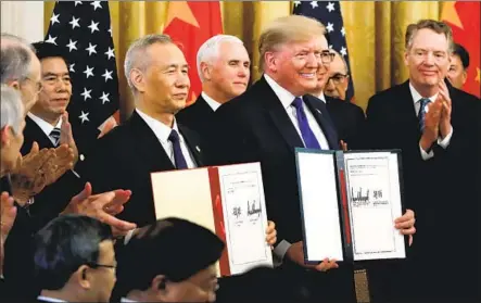  ?? Mark Wilson Getty Images ?? PRESIDENT Trump and Chinese Vice Premier Liu He hold up signed Phase 1 trade deal agreements Wednesday at the White House.