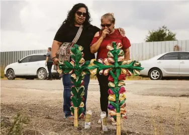  ?? Jay Janner / Associated Press ?? Debra Ponce (left) and Angelita Olvera pray for the victims where they were found near San Antonio.