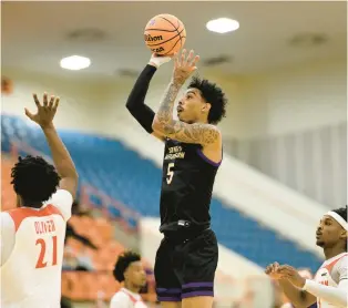  ?? NICK WASS/AP ?? James Madison guard Terrence Edwards, who scored his 1,000th college point Friday, shoots against Morgan State forward Christian Oliver, left, and guard Rob Lawson during the first half in Baltimore.