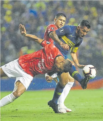  ?? M. ALFiERi ?? Carlos tevez maniobra bajo la lluvia ante la oposición de un defensor de Wilsterman­n