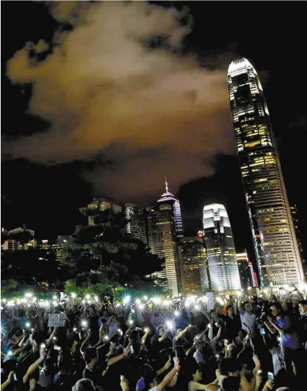  ?? Vincent Yu/ Associated Press ?? Manifestan­tes de Hong Kong levantam seus telefones celulares em protesto contra a política chinesa para o território