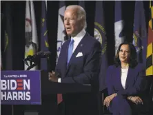  ?? Olivier Douliery / AFP via Getty Images ?? Sen. Kamala Harris listens as former VP Joe Biden speaks during a news conference together in Wilmington, Del.