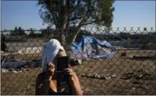  ?? JAE C. HONG — THE ASSOCIATED PRESS ?? With a towel wrapped around her head, Stella Perez, who is homeless, applies makeup in the parking lot of Angel Stadium after taking a shower in Showers of Blessing, a mobile shower trailer built to provide free showers to homeless people, Tuesday in...