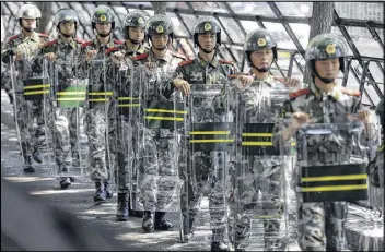  ?? NG HAN GUAN / AP ?? Chinese paramilita­ry police march with their shields outside the entrance to the Japanese Embassy in Beijing, China, on Wednesday. People across China have engaged in days of furious protests over disputed East China Sea islands.