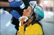  ?? NOAH BERGER PHOTOS / ASSOCIATED PRESS ?? A medic treats Black Lives Matter protester Lacey Wambalaba after exposure to chemical irritants deployed by federal officers on Friday in Portland, Ore.