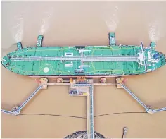 ??  ?? An oil tanker unloads crude oil at a crude oil terminal in Zhoushan, Zhejiang province, China. — Reuters photo