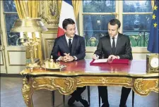  ?? (Photo AFP ?? Emmanuel Macron a signé, hier en direct, sous l’oeil attentif des caméras et de Benjamin Griveaux, porte-parole du gouverneme­nt, les trois dernières lois votées au Parlement dont le budget .