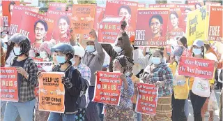  ?? — AFP photo ?? Protesters hold up signs calling for the release of detained Suu Kyi during a demonstrat­ion against the military coup in Naypyidaw.