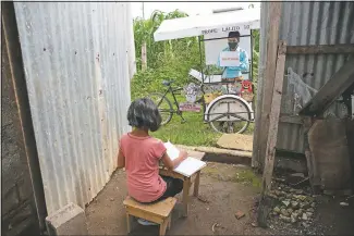  ??  ?? G erardo Ixcoy teaches 12-year-old student Paola Ximena Conoz about fractions on July 15 from his mobile classroom, parked just outside the door to her home in Santa Cruz del Quiche, Guatemala.
(File Photo/AP/Moises Castillo)