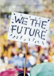  ??  ?? A student holds a banner aloft during the march to the Union Buildings in Pretoria.