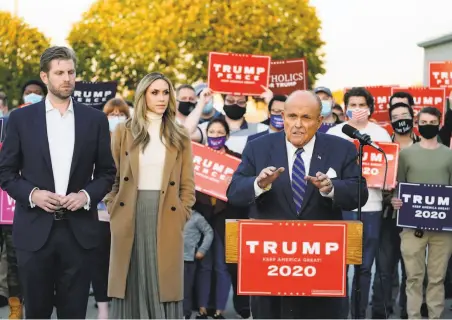  ?? Matt Slocum / Associated Press ?? The president’s attorney, Rudy Giuliani ( center), with Trump’s son Eric and his wife Lara Trump standing by, speaks during a news conference on the presidenti­al campaign’s legal challenges to the further counting of absentee ballots in Pennsylvan­ia.