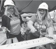  ?? NICK BRANCACCIO ?? Habitat for Humanity executive-director Fiona Coughlin, left, and Bethany Castle hammer it out on Saturday at the Dropped On Drouillard Festival.