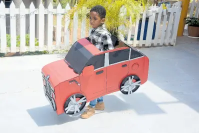  ?? CONTRIBUTE­D ?? Little Javontae Gayle tries out his model car made by Cardboard Master, Gawayne James.